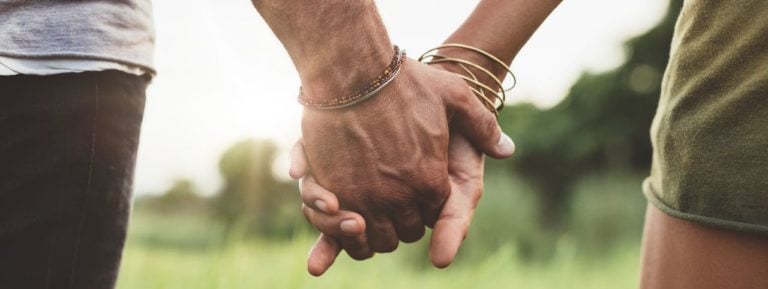 Mann und Frau halten Hände.